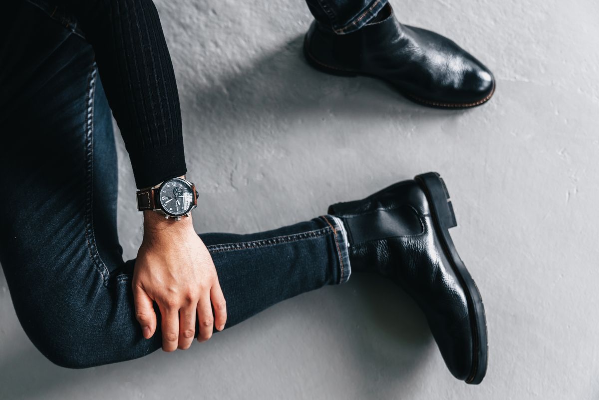 Black leather Chelsea boots worn with slim dark trousers