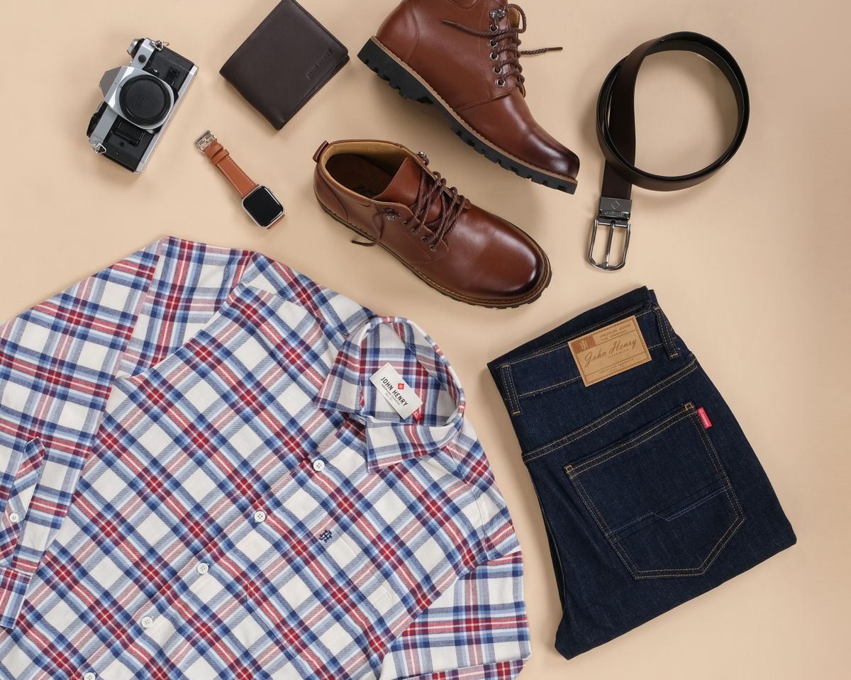Brown leather shoes laid out with jeans, a checked shirt, and a brown belt