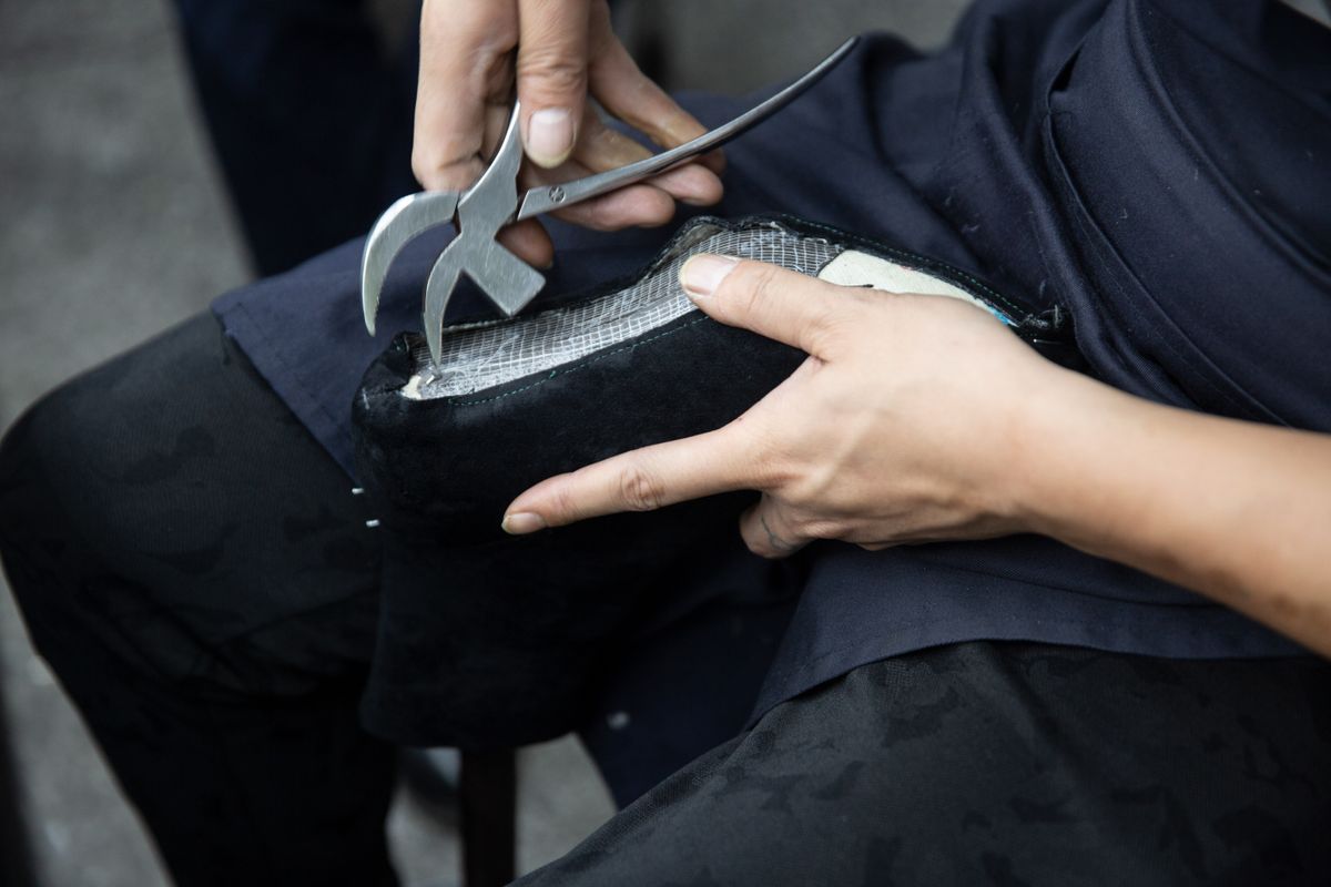 Hands holding a shoe sole during a repair