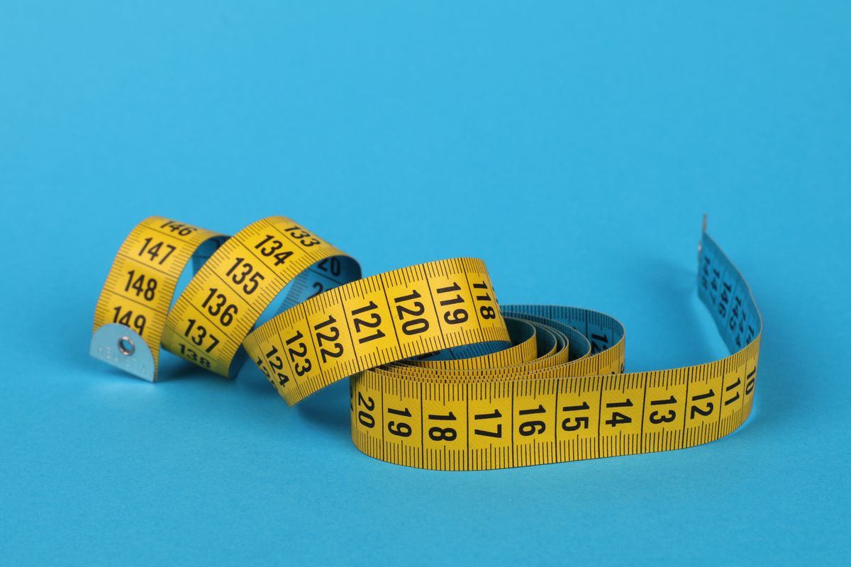 Yellow measuring tape on a blue background