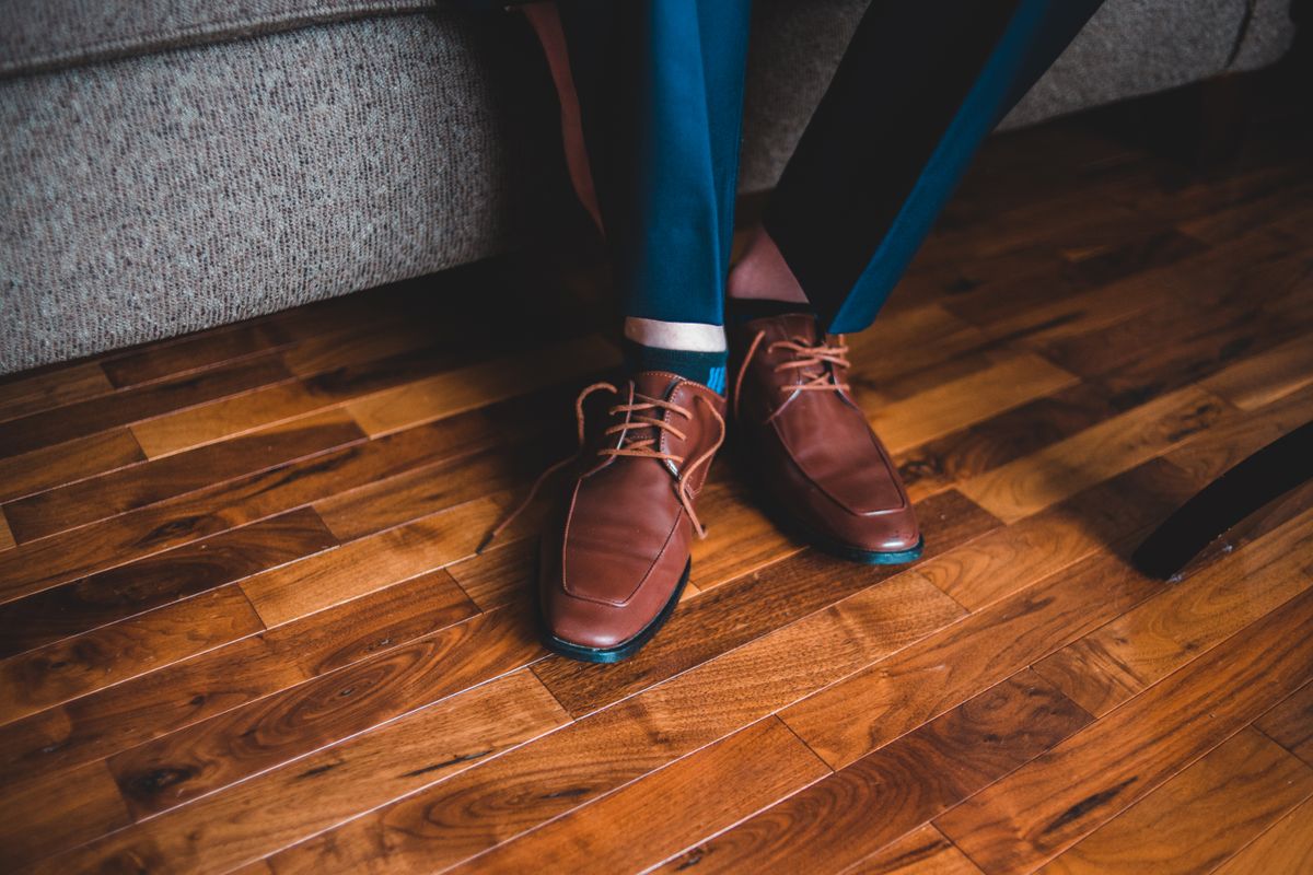 Navy suit trousers with brown leather dress shoes on a wooden floor